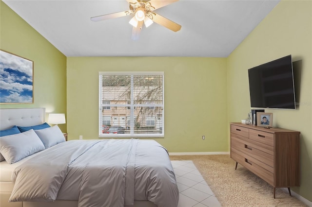 bedroom featuring ceiling fan, light tile patterned flooring, light colored carpet, and baseboards