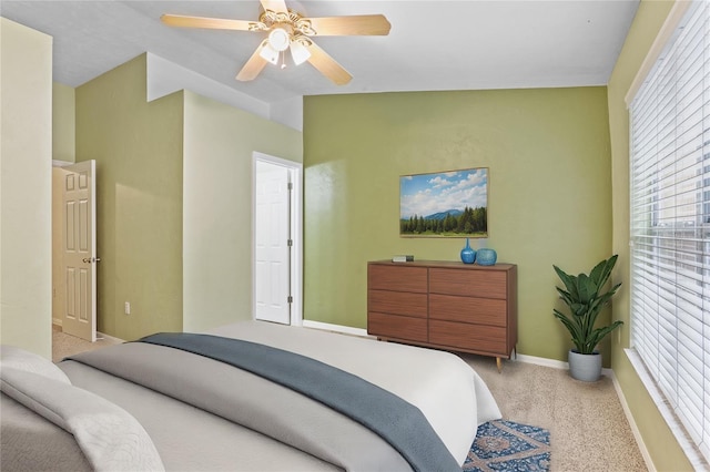 bedroom with light carpet, baseboards, vaulted ceiling, and a ceiling fan