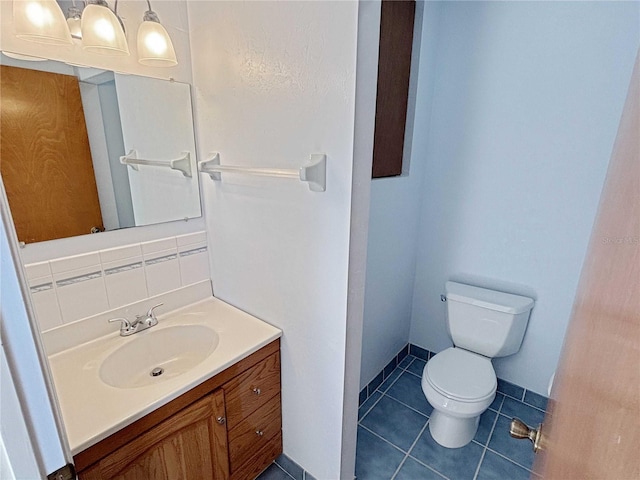 bathroom featuring baseboards, decorative backsplash, toilet, tile patterned floors, and vanity