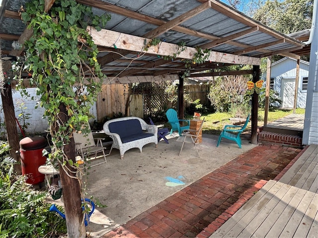 view of patio / terrace with an outbuilding, fence, a storage shed, and a pergola