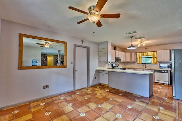 kitchen featuring a peninsula, stainless steel appliances, light countertops, under cabinet range hood, and a sink