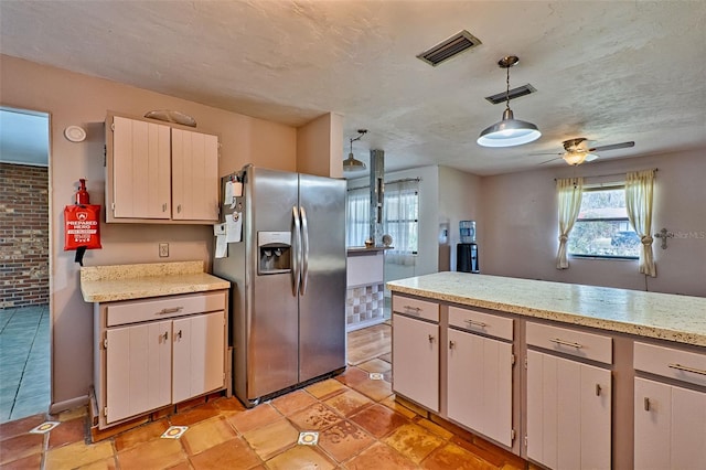 kitchen with ceiling fan, visible vents, pendant lighting, and stainless steel fridge with ice dispenser