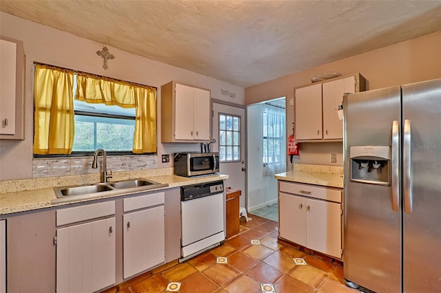 kitchen featuring plenty of natural light, appliances with stainless steel finishes, light countertops, and a sink