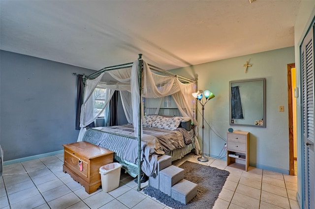 bedroom with baseboards and tile patterned floors