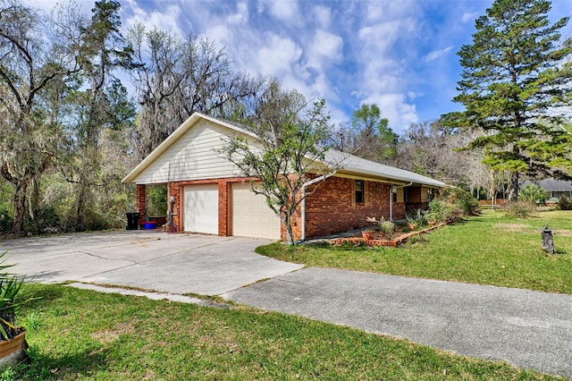 view of side of home with a garage, concrete driveway, brick siding, and a yard