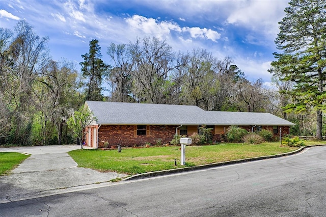 single story home with an attached garage, brick siding, driveway, and a front lawn