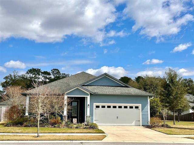 single story home with driveway, roof with shingles, an attached garage, and fence