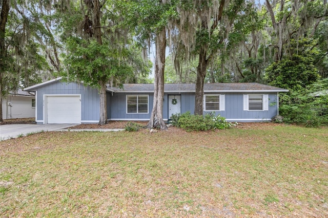 ranch-style house featuring an attached garage, a front lawn, and concrete driveway