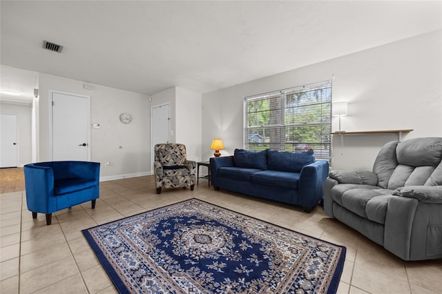 living area featuring light tile patterned flooring, visible vents, and baseboards