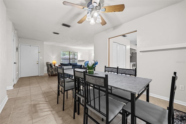 dining room with baseboards, visible vents, ceiling fan, and light tile patterned flooring