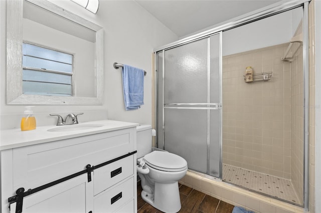 full bath featuring vanity, a stall shower, wood finished floors, and toilet