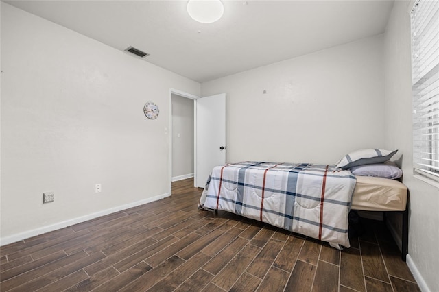 bedroom featuring wood tiled floor, visible vents, and baseboards