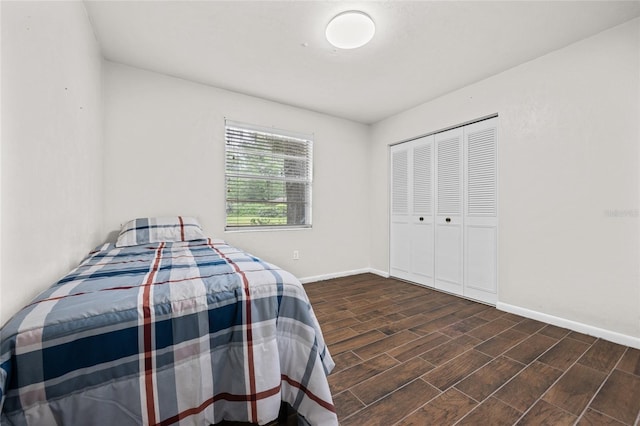 bedroom with a closet, baseboards, and wood finished floors