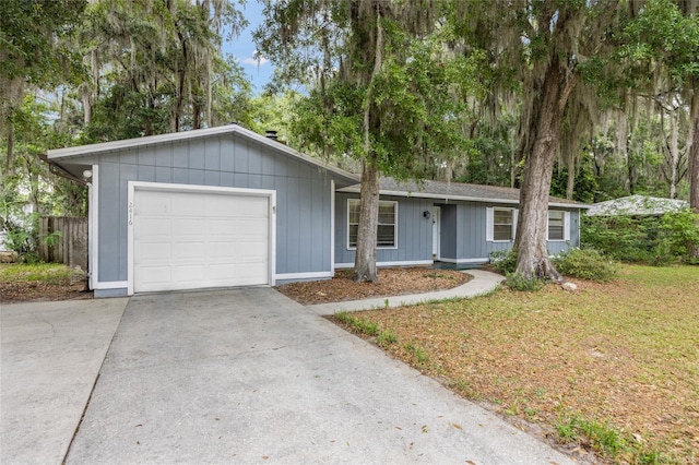 ranch-style house featuring a garage, concrete driveway, and a front yard