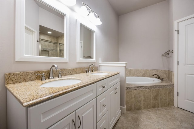 bathroom with double vanity, a stall shower, a sink, and a bath