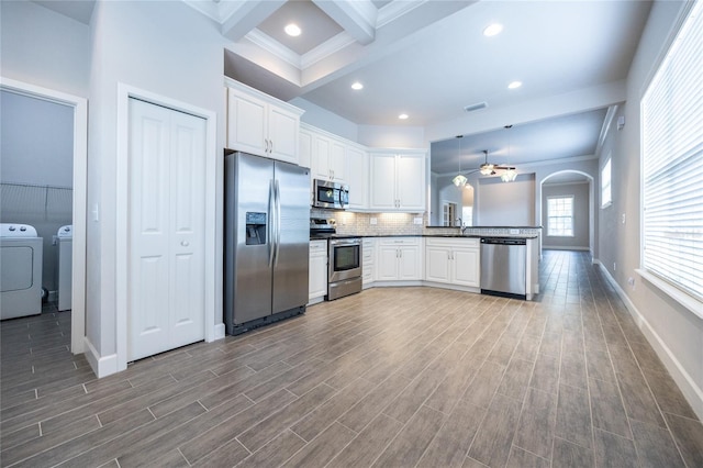 kitchen featuring stainless steel appliances, separate washer and dryer, a sink, visible vents, and beam ceiling