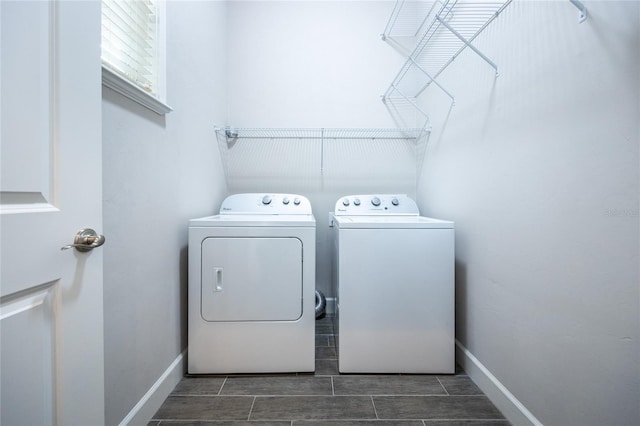 clothes washing area with laundry area, washing machine and dryer, baseboards, and wood finish floors