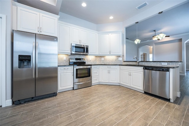 7625 SW 24th Ln, Gainesville, FL 32608 - kitchen with appliances with stainless steel finishes, a sink, dark countertops, ceiling fan, and decorative backsplash