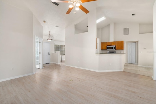 unfurnished living room with light wood-style flooring, visible vents, and baseboards