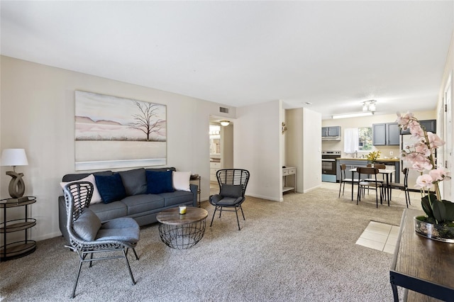 living area with visible vents, light carpet, and baseboards