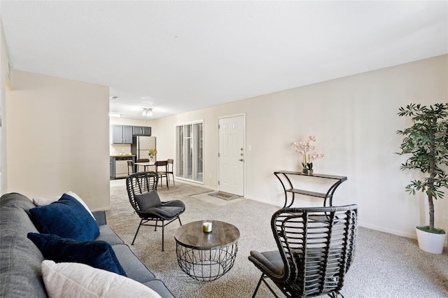 living room with baseboards and light colored carpet