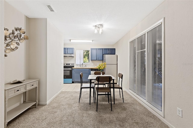 dining room featuring baseboards, visible vents, a textured ceiling, and light colored carpet