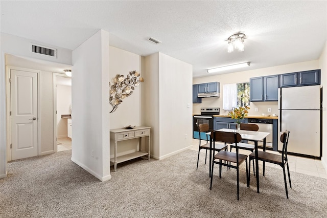 dining room with light carpet, a textured ceiling, and visible vents