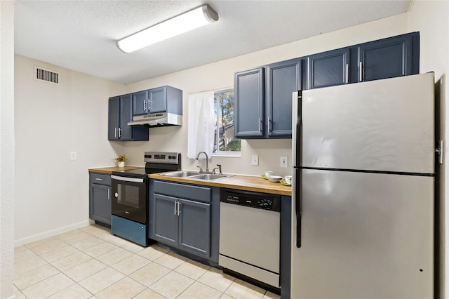 kitchen featuring visible vents, wooden counters, appliances with stainless steel finishes, a sink, and under cabinet range hood