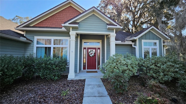 entrance to property featuring a shingled roof and board and batten siding