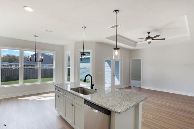 kitchen featuring a sink, visible vents, open floor plan, dishwasher, and a tray ceiling