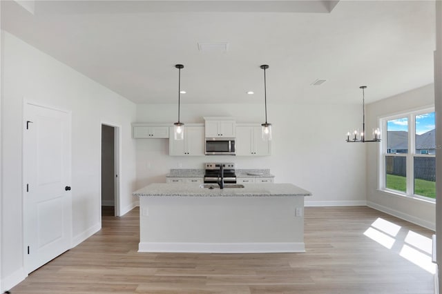 kitchen with stainless steel appliances, a sink, baseboards, white cabinets, and light wood-type flooring