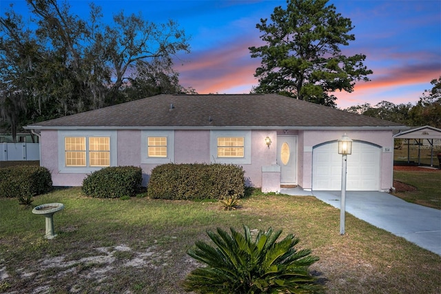 single story home with a garage, a front yard, driveway, and stucco siding