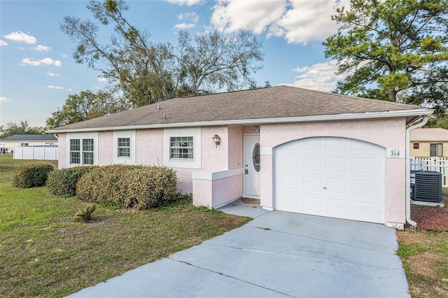 ranch-style home with a garage, driveway, a front lawn, and stucco siding