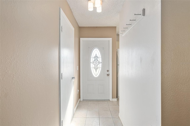 doorway with light tile patterned floors, a textured wall, and a textured ceiling