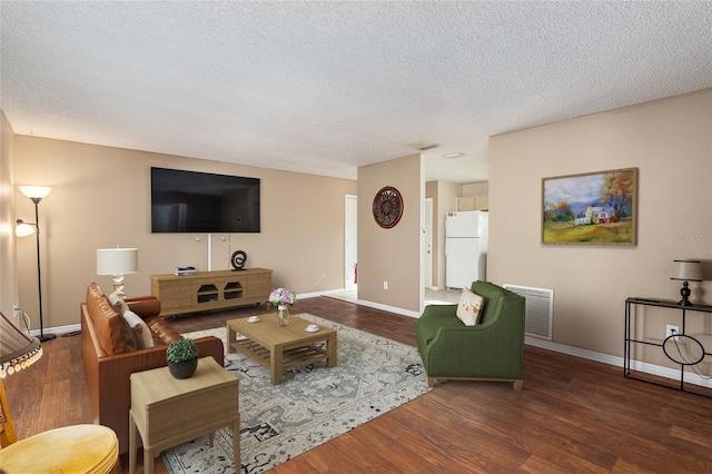 living area featuring a textured ceiling, wood finished floors, visible vents, and baseboards