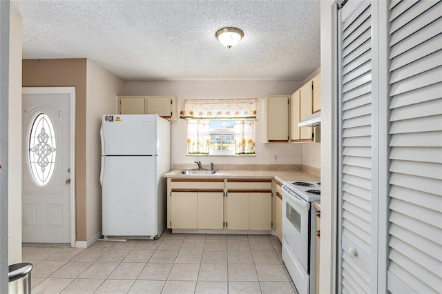 kitchen with cream cabinets, under cabinet range hood, white appliances, a sink, and light countertops