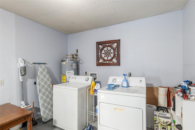 laundry room featuring laundry area, water heater, a textured ceiling, and separate washer and dryer