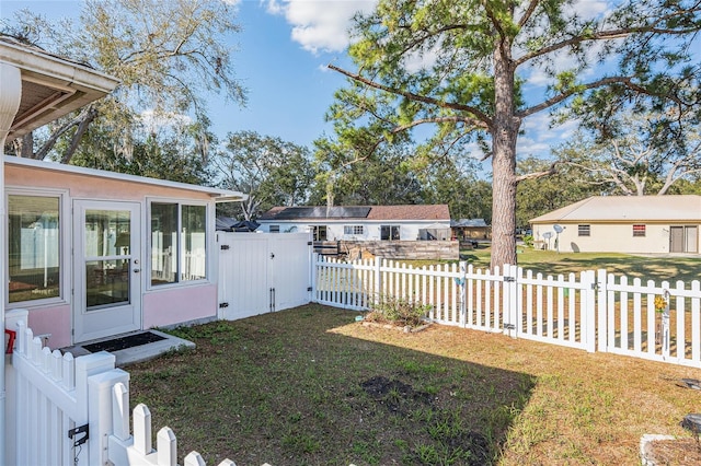 view of yard with a fenced front yard and a gate