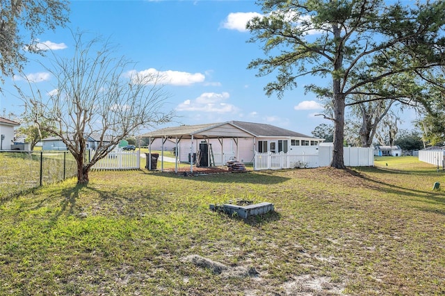 rear view of house with a fenced backyard and a yard