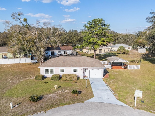 view of front of house with a garage, concrete driveway, a front yard, and fence