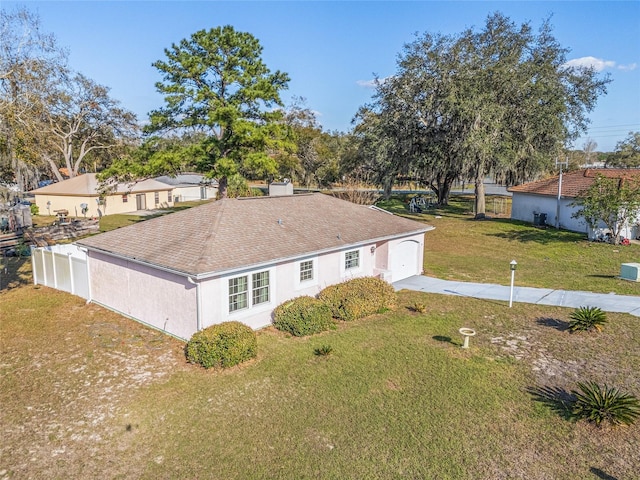 view of front of house with a garage, driveway, roof with shingles, stucco siding, and a front yard