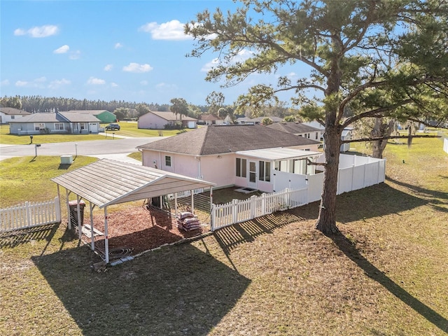 back of house featuring a lawn, a fenced backyard, and a residential view