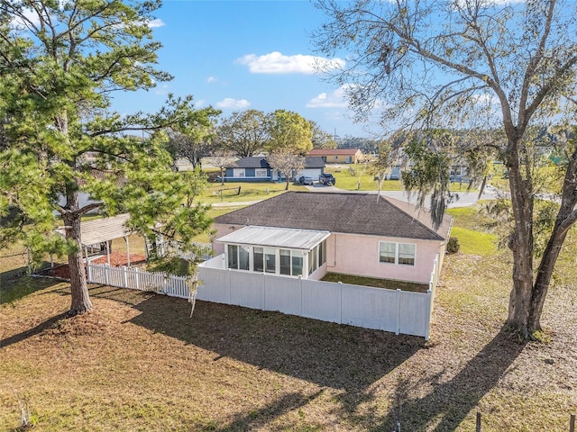 back of house featuring a sunroom, fence, and stucco siding