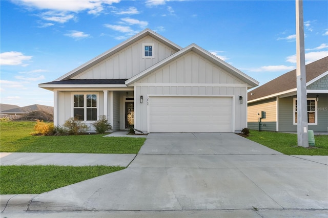 view of front of property with board and batten siding, a garage, driveway, and a front lawn