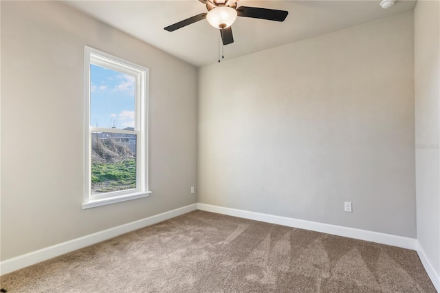 empty room featuring carpet floors, plenty of natural light, a ceiling fan, and baseboards