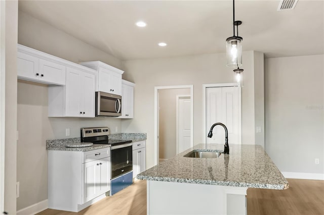 kitchen with a sink, visible vents, white cabinets, appliances with stainless steel finishes, and light wood-type flooring