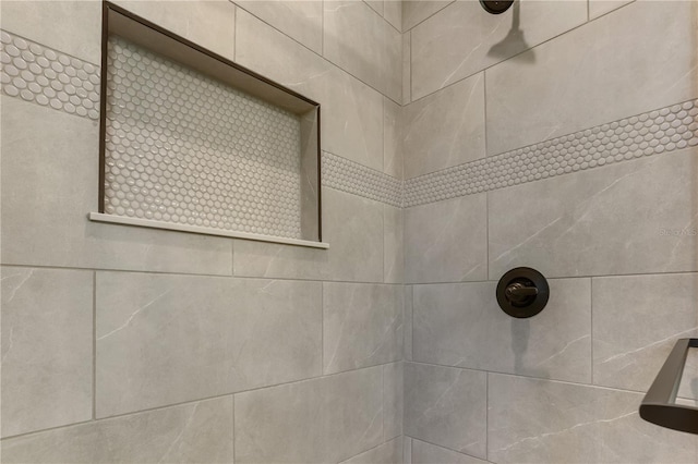 interior details featuring a tile shower