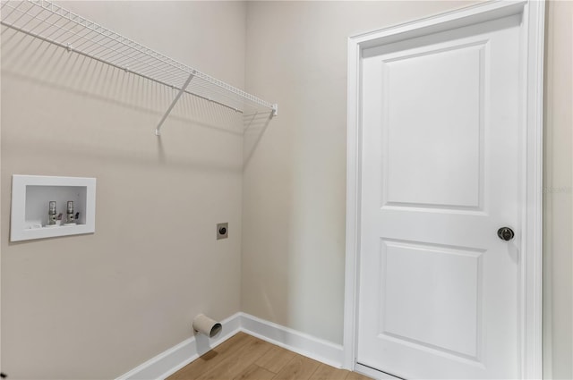 clothes washing area with laundry area, baseboards, hookup for a washing machine, hookup for an electric dryer, and light wood-style floors