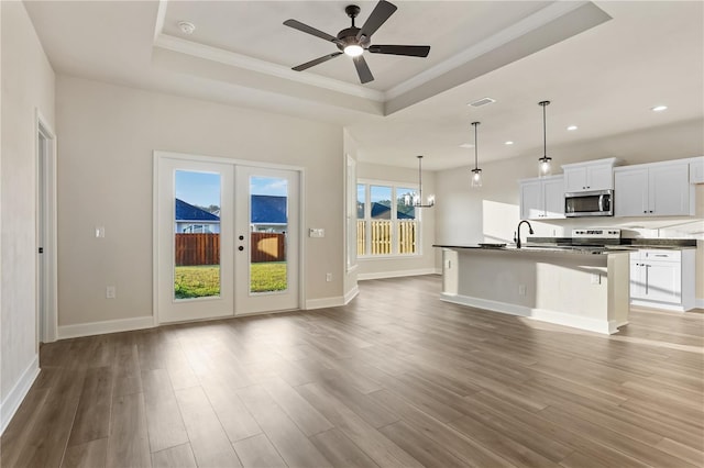 kitchen featuring stainless steel appliances, dark countertops, and a raised ceiling