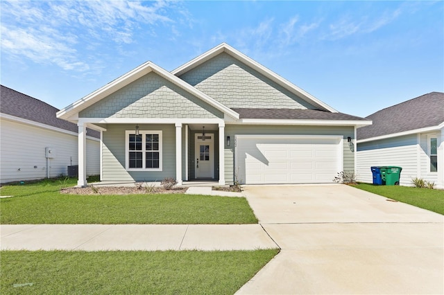 view of front of property featuring a garage, a front yard, concrete driveway, and central AC unit